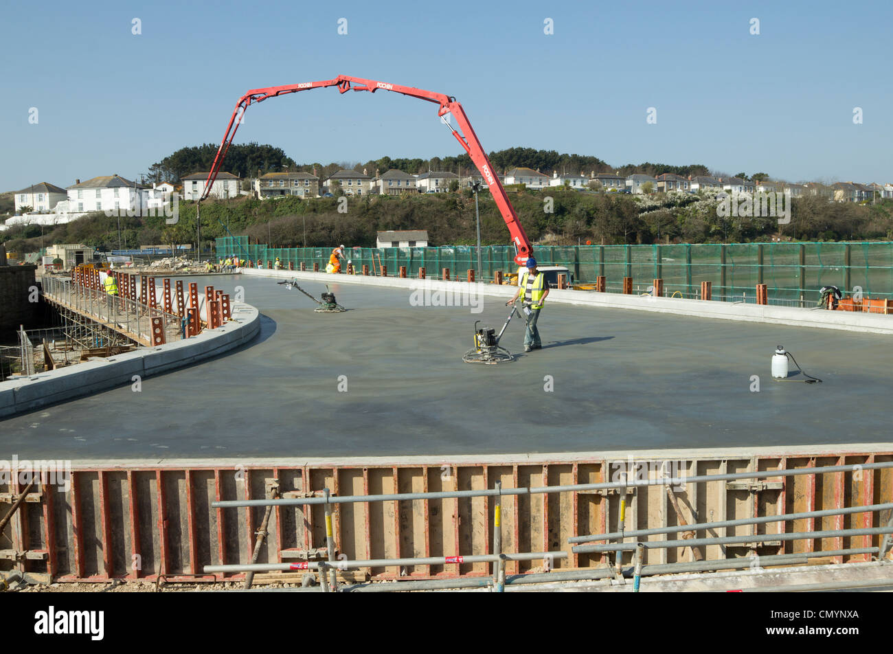 La levigatura del calcestruzzo durante il calcestruzzo versare per la piattaforma del nuovo ponte sul Pool Copperhouse in Hayle, Cornwall Regno Unito. Foto Stock