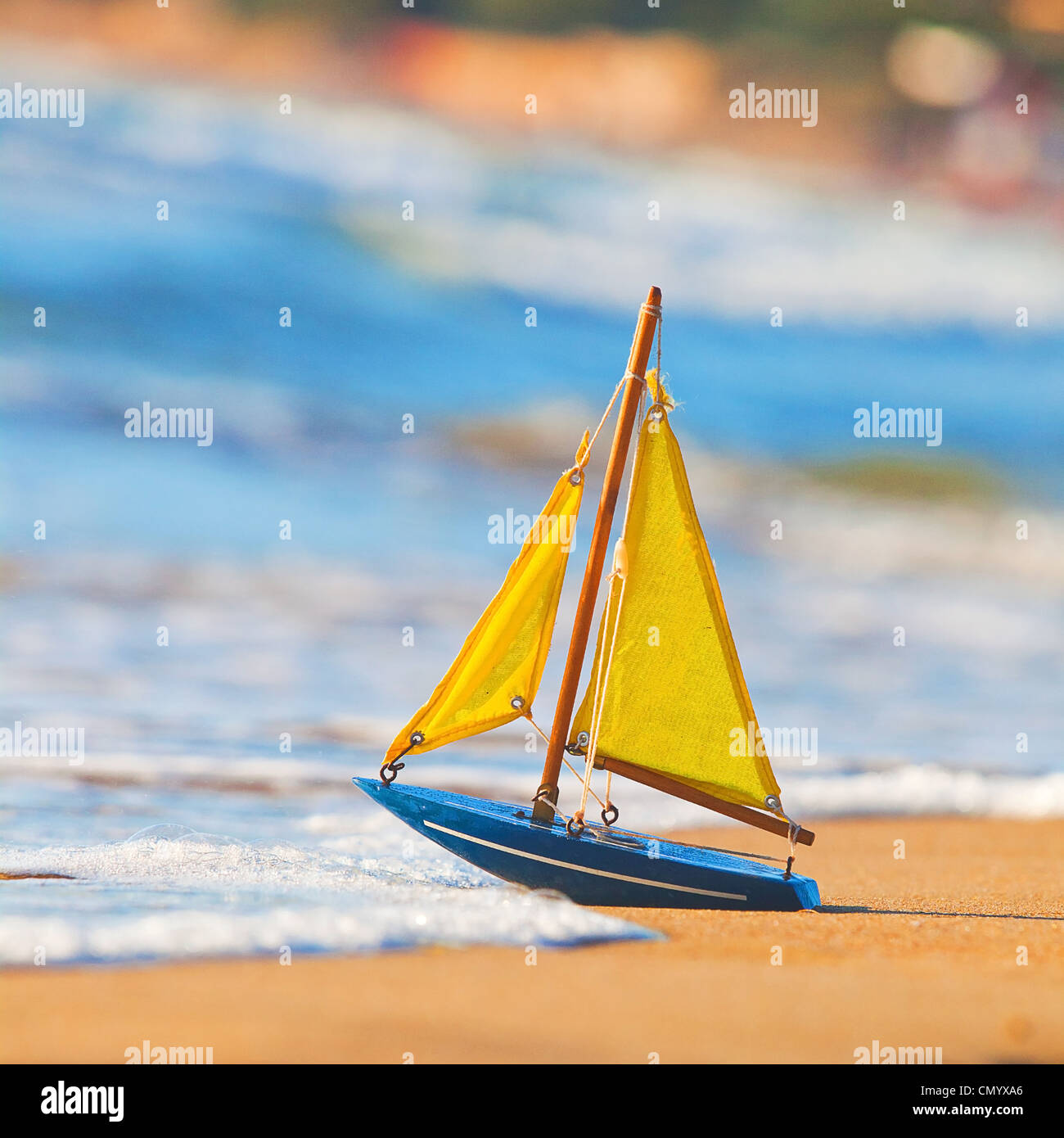 La piccola barca giocattolo sorge sulla spiaggia sabbiosa Foto Stock
