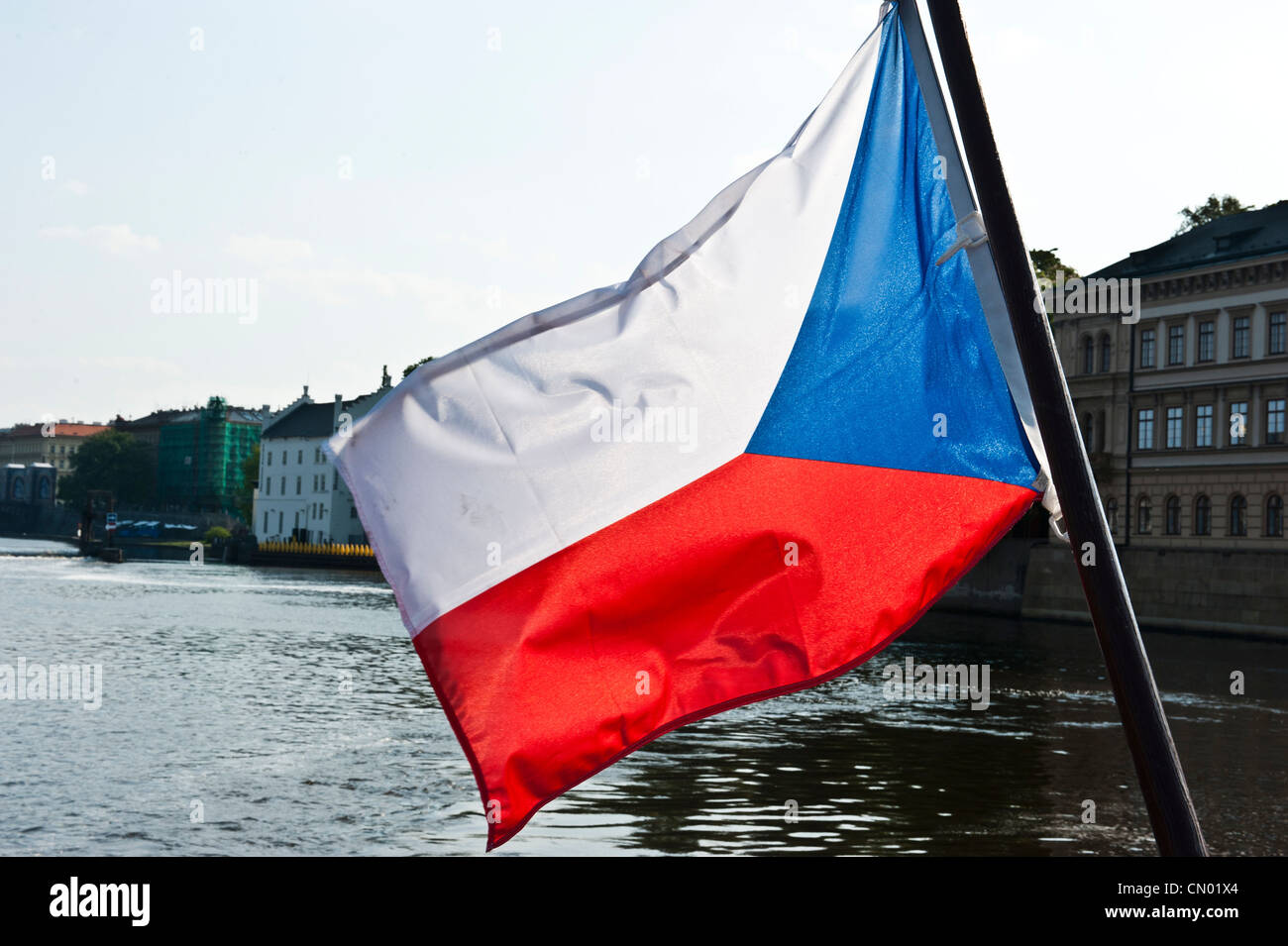 Una Bandiera della Repubblica ceca che soffia nella brezza, posizionata al di sopra del fiume Vltava. Foto Stock