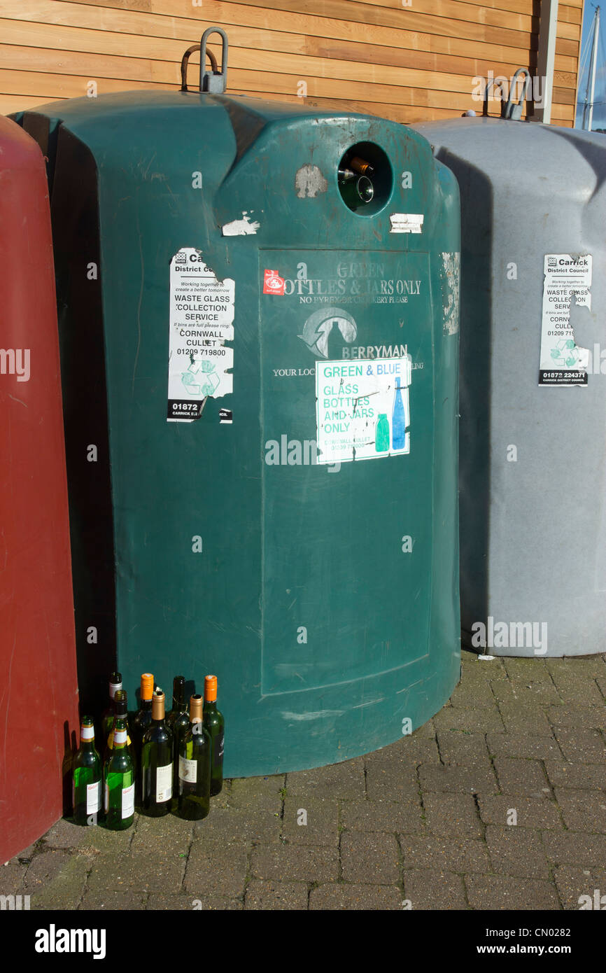 Il verde e il blu di bottiglie di vetro e di vasi cestino pieno di bottiglie di vino sul pavimento, Falmouth UK. Foto Stock