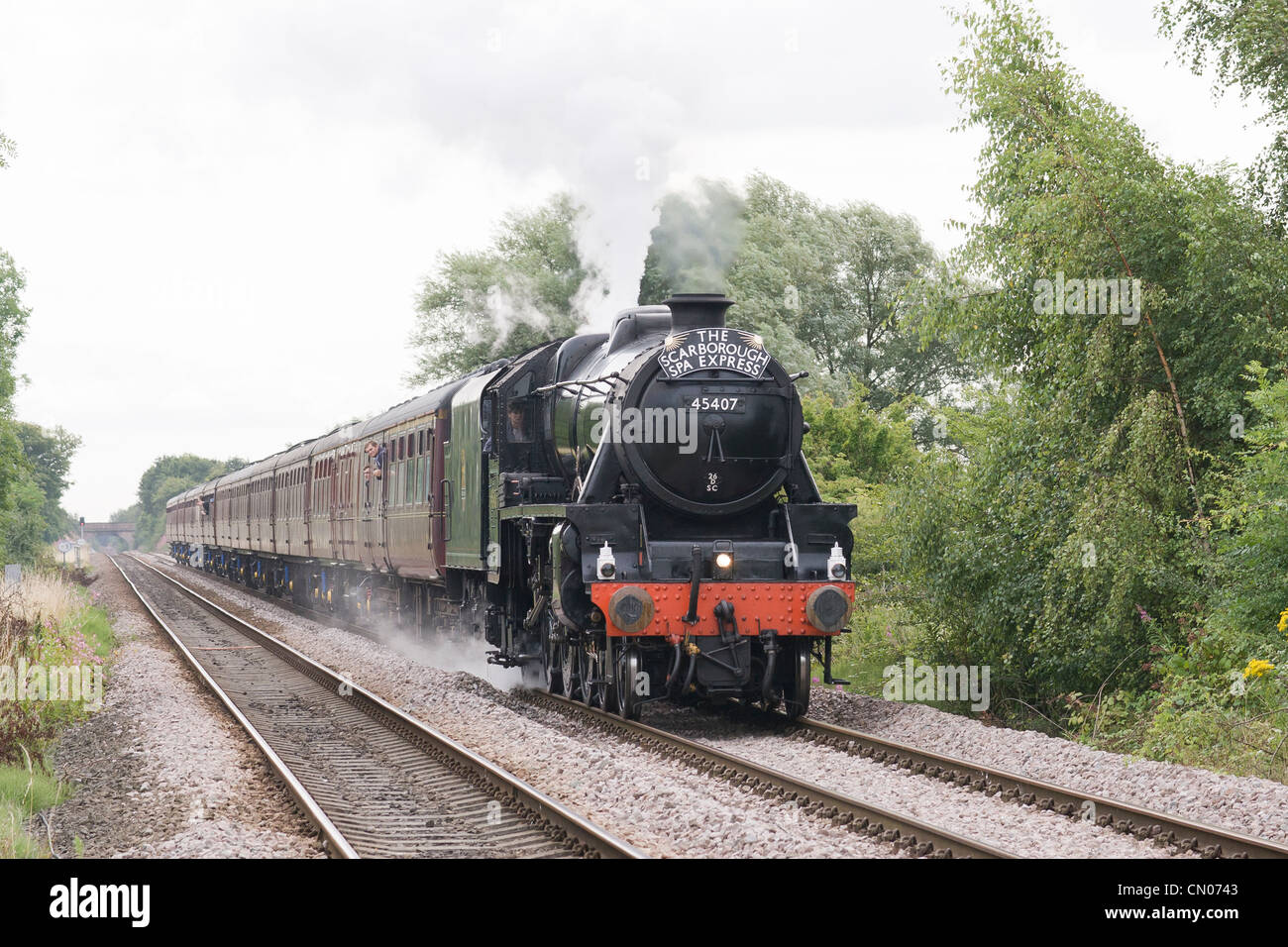 Locomotiva a vapore la trazione di un treno passeggeri sulla linea principale Foto Stock