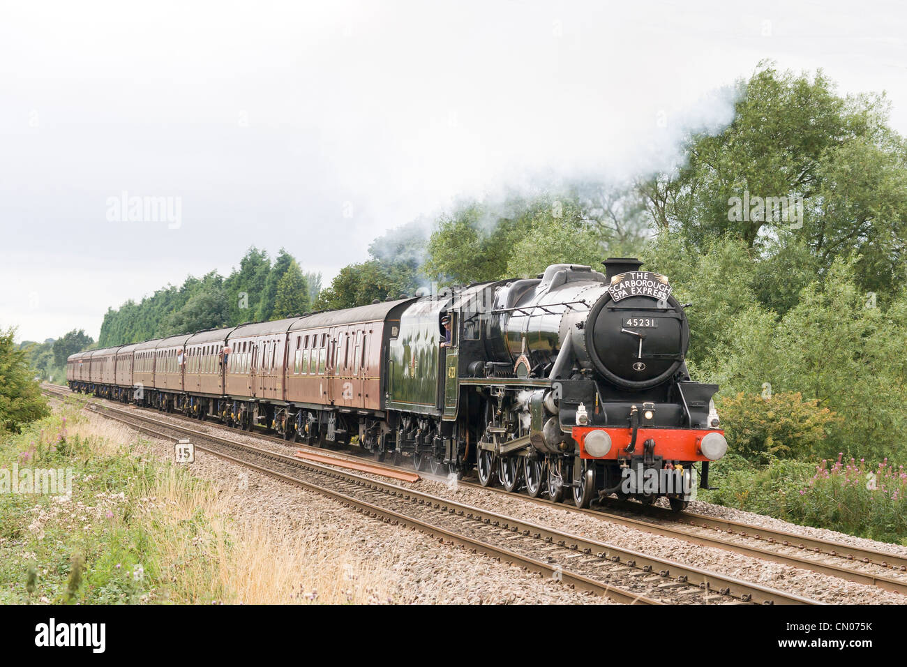 Locomotiva a vapore la trazione di un treno passeggeri sulla linea principale Foto Stock