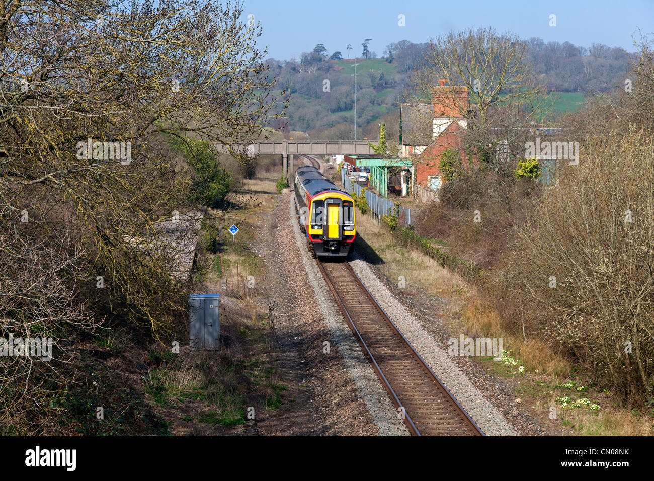 A sud-ovest di treni servizio Exeter-Waterloo passando la stazione in disuso, Seaton Junction, Devon Foto Stock