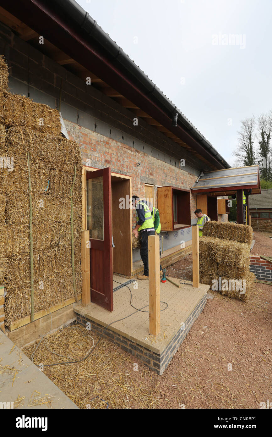 I costruttori utilizzano la paglia per l'isolamento su un nuovo eco-friendly building Foto Stock