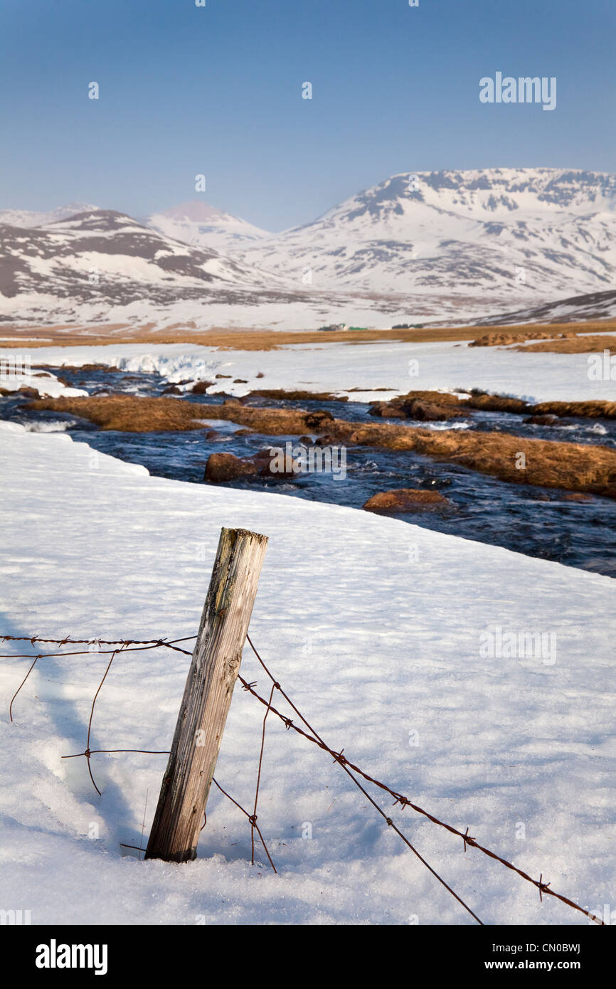 Coperta di neve paesaggio di campagna e il fiume al di fuori di Reykjavik, Islanda. Foto Stock