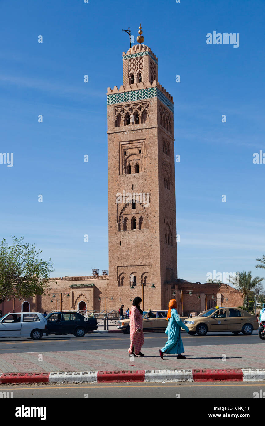 Due donne arabe tranquillamente a piedi lungo il marciapiede con il sottofondo di Koutoubia Foto Stock