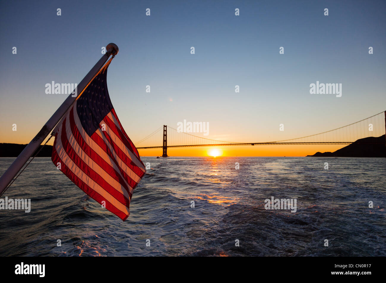 Bandiera americana e il Golden Gate Bridge al tramonto di San Francisco California USA Foto Stock