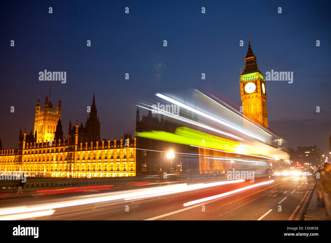 Big Ben Clock Tower Case del Parlamento durante la notte con le luci sfocate di passaggio di red bus londinese in primo piano Londra Inghilterra REGNO UNITO Foto Stock