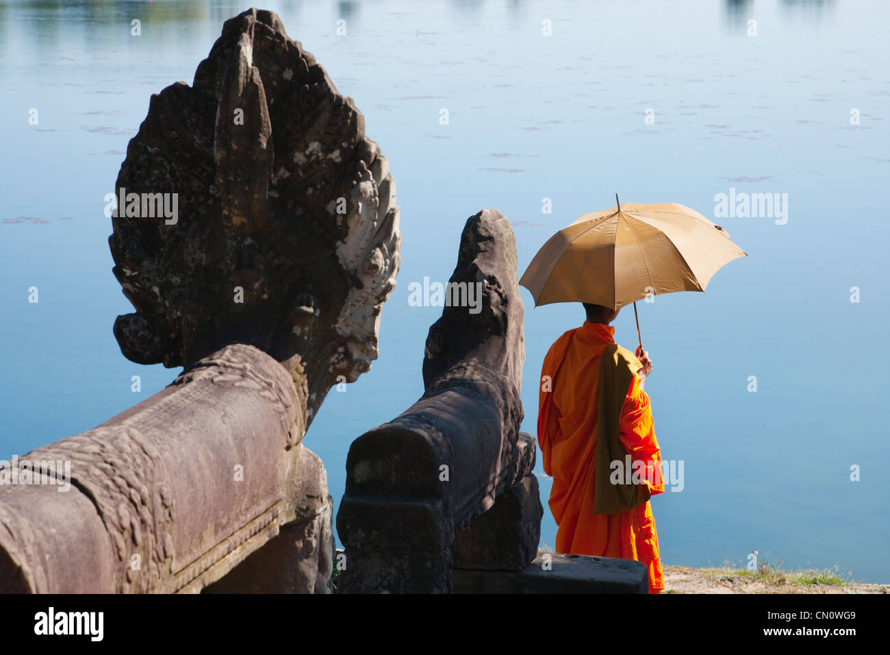 Monaco con lion statua da SRA Srang, la piscina delle abluzioni, sito Patrimonio Mondiale dell'UNESCO, Cambogia Foto Stock