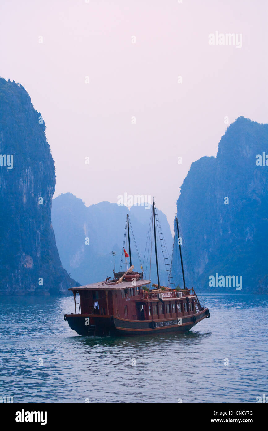 Junk barche e isole carsico nella baia di Halong, sito Patrimonio Mondiale dell'UNESCO, la baia di Ha Long, Vietnam Foto Stock