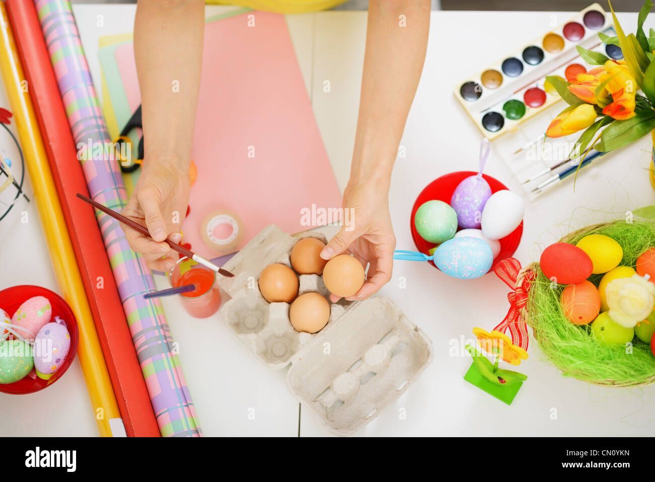 I preparativi per la festa di Pasqua. Primo piano sulle mani pittura su uovo. Foto Stock