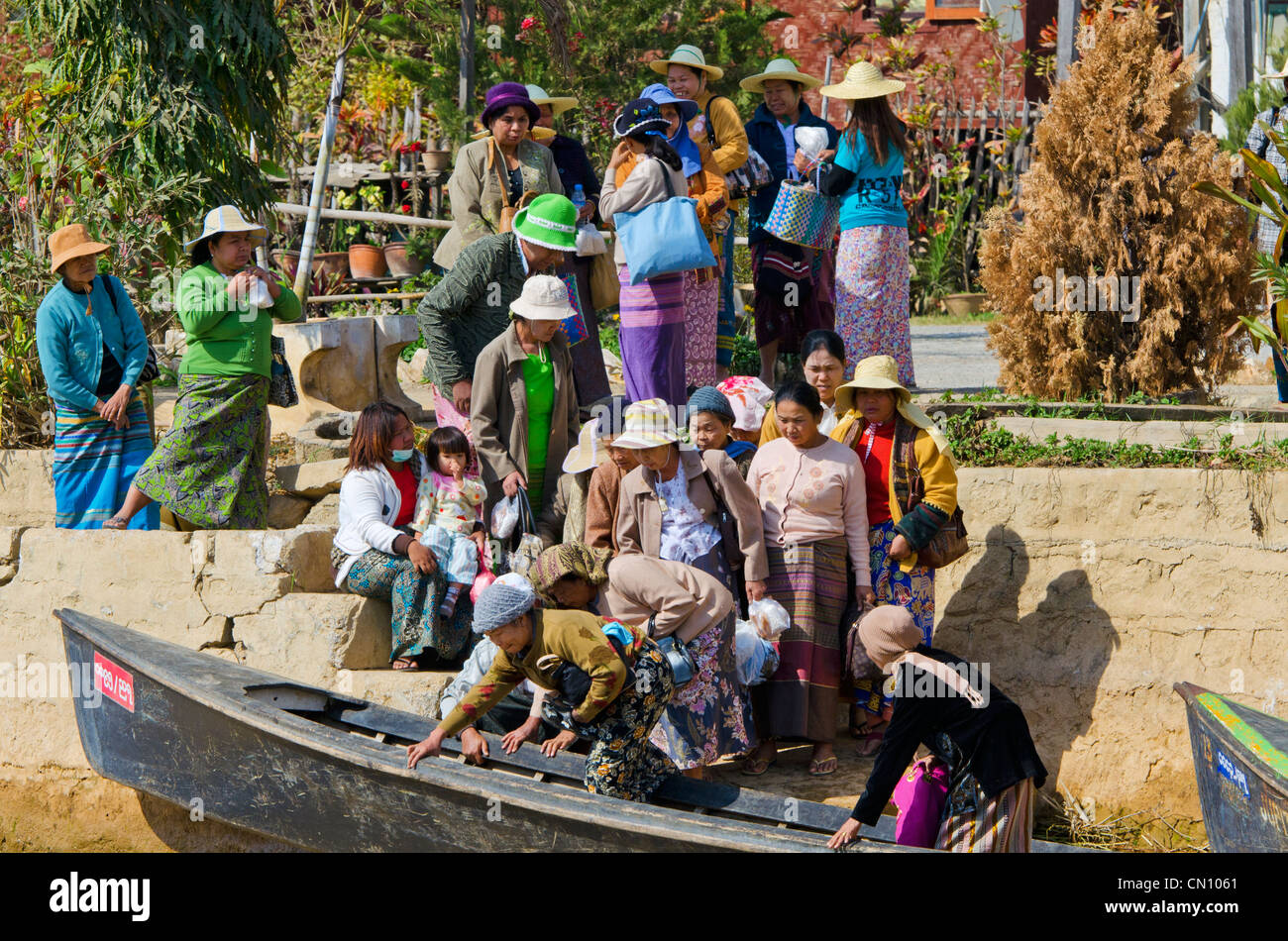 Grande folla di donne di salire a bordo di barche, Nyaungshwe, Lago Inle, Myanmar Foto Stock