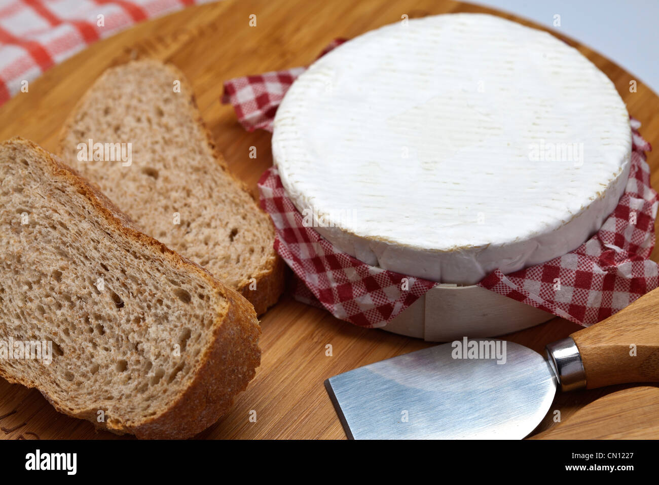 Mini Camembert sulla scheda di formaggio bianco con pane integrale Foto Stock