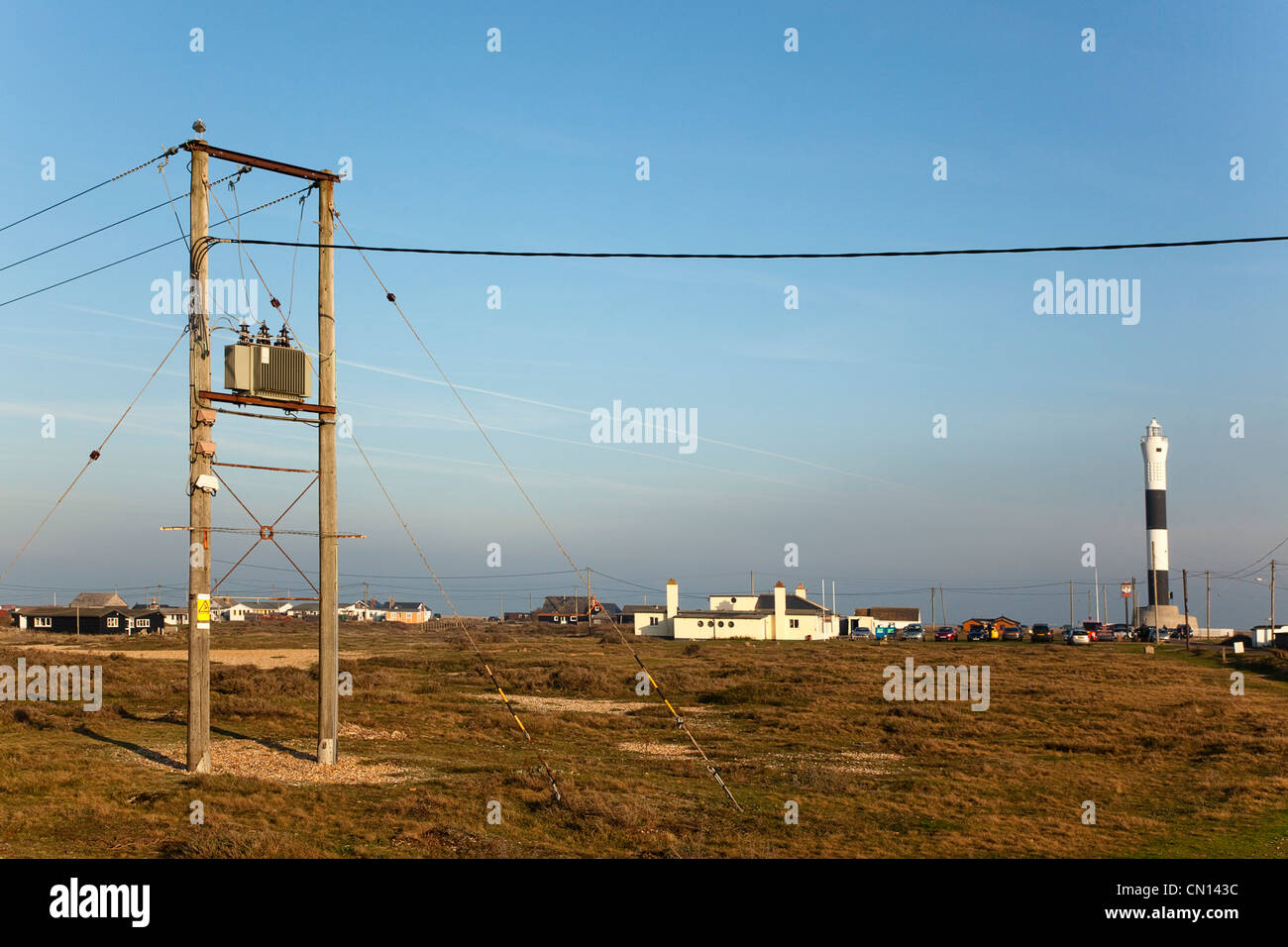 Inghilterra, Kent, Romney Marsh, Dungeness, vista verso la ferrovia leggera Cafe con i cavi di potenza in primo piano. Foto Stock