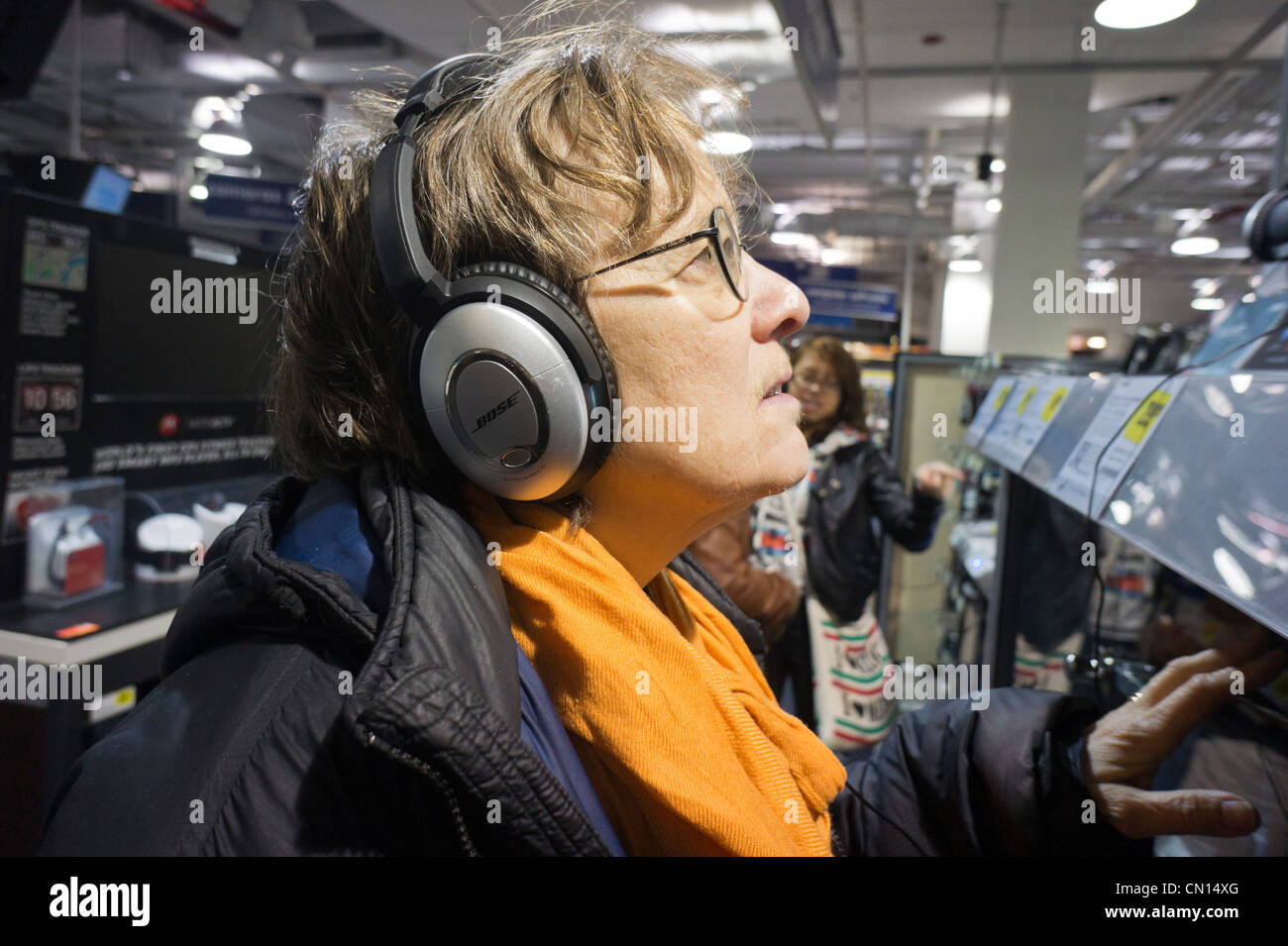 Un cliente in un negozio Best Buy in New York ascolta su cuffie Bose Foto Stock