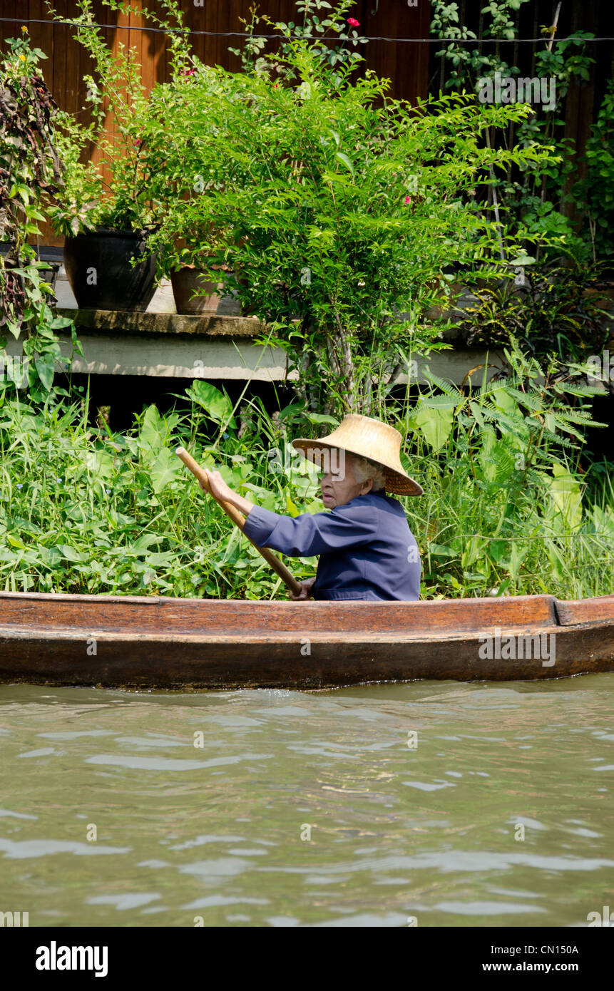 Thailandia, Mercato Galleggiante di Damnoen Saduak. Vecchia donna fornitore nel canal boat vendita di produrre lungo i corsi d'acqua. Foto Stock