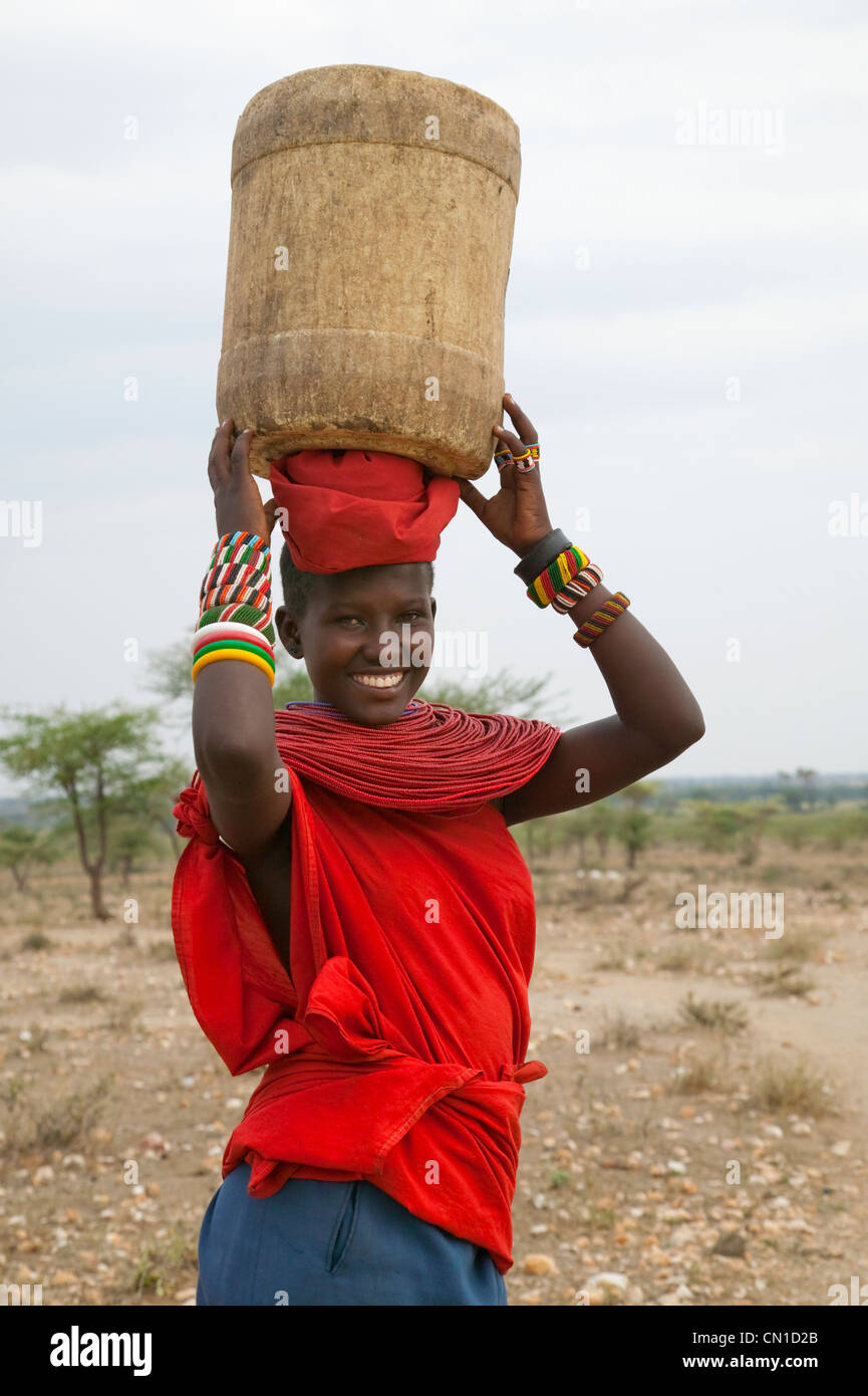 Samburu tribeswoman cestello di trasporto sulla testa, Samburu riserva nazionale, Kenya Foto Stock