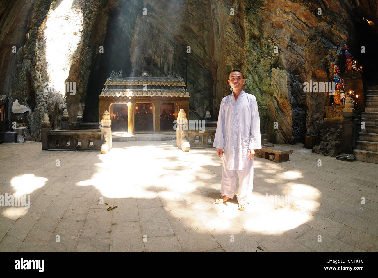 Montagne di marmo, sacerdote nel raggio di luce illuminando Huyen Khong grotta. Danang, Vietnam Foto Stock