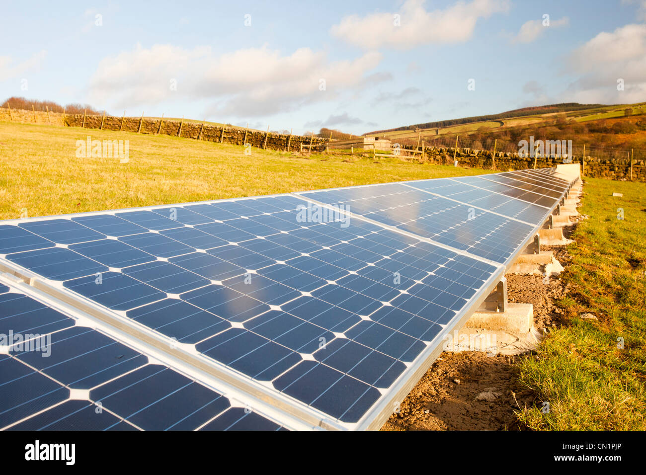 Un agriturismo sul bordo di Ilkley Moor che dispone di pannelli solari nel campo dietro la casa colonica per aiutare la potenza della casa. Foto Stock