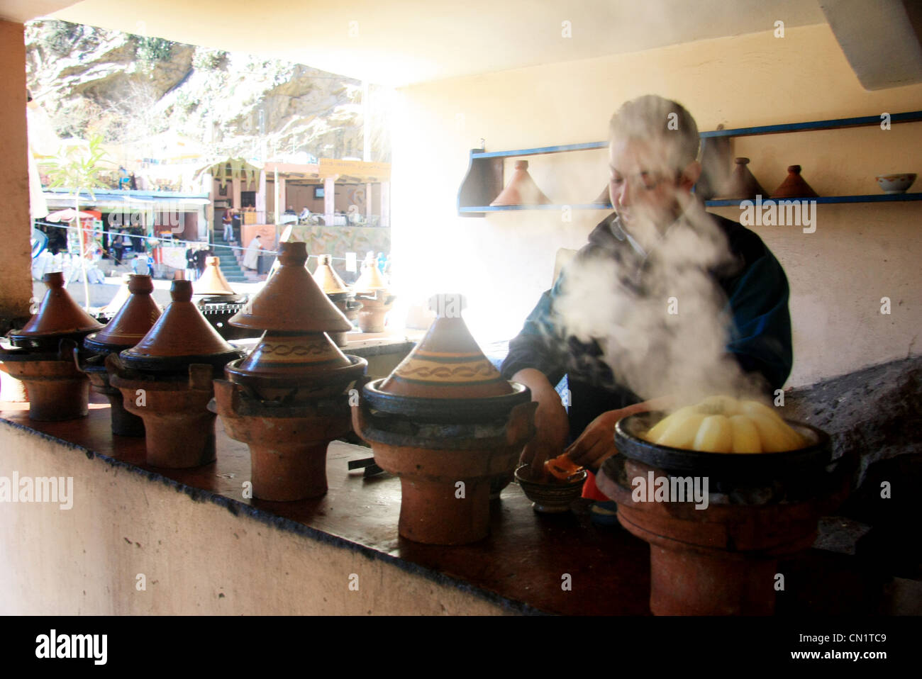 Lo chef cucinare i tipici piatti berbero, gli ingredienti di base di una tagine, presso un ristorante tradizionale di Setti Fatma, Ourika Valley, Marocco. Foto Stock