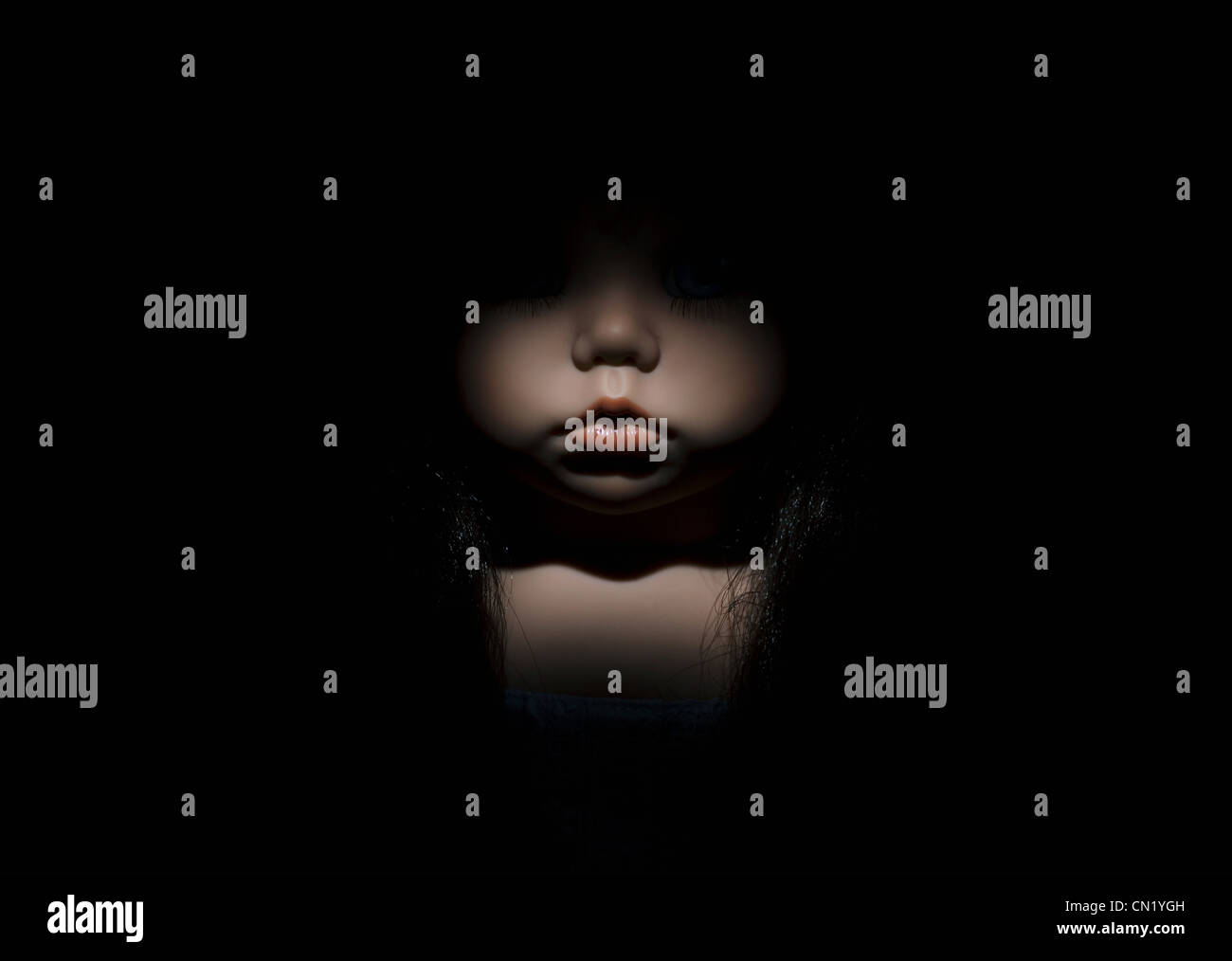 La bambola il suo volto nel buio, close up Foto Stock