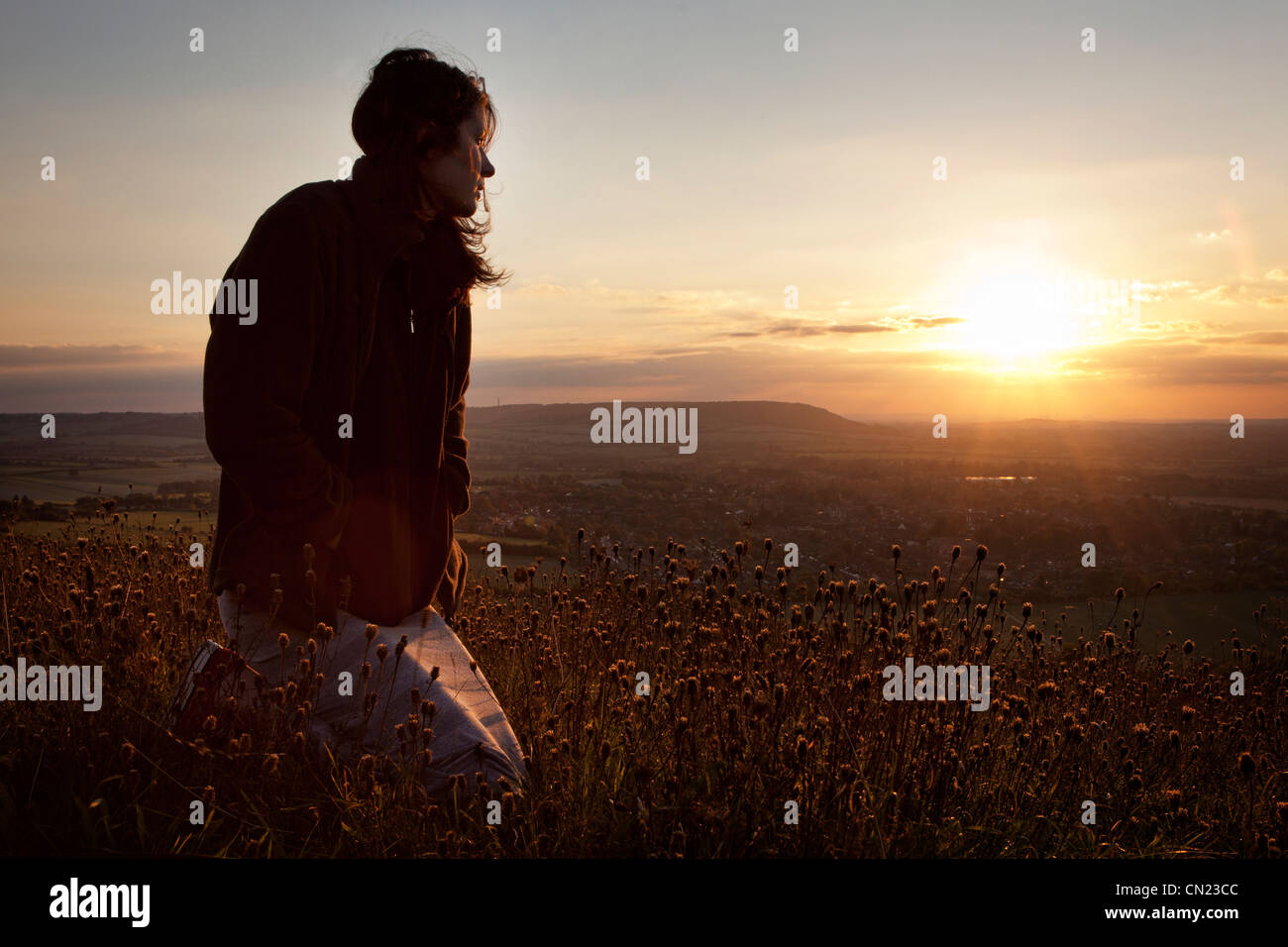 Donna che guarda fuori oltre il paesaggio inglese Foto Stock