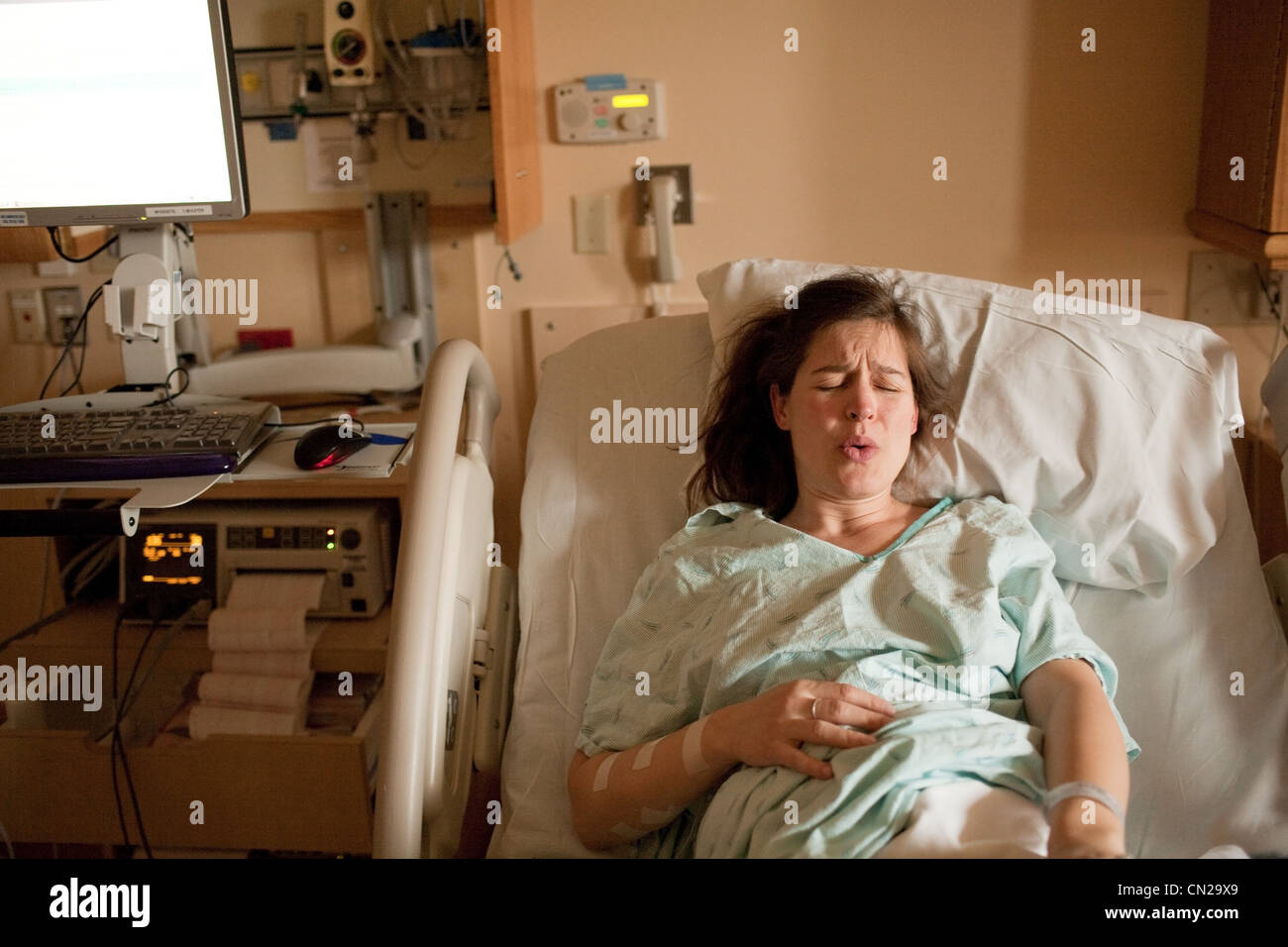 Donna incinta di manodopera sul letto di ospedale Foto Stock