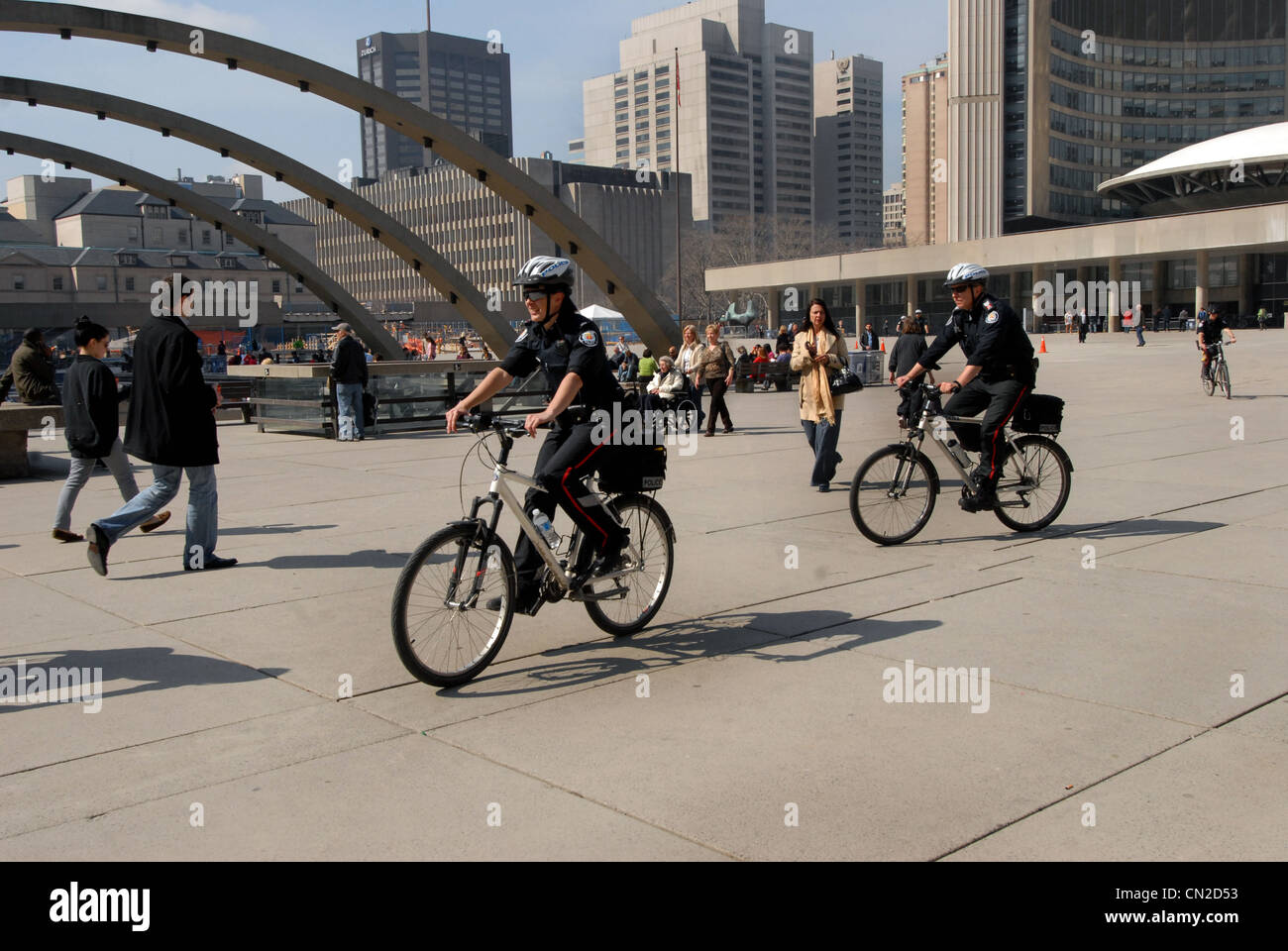 Polizia canadesi in bicicletta attraverso Nathan Phillips Square a Toronto Foto Stock