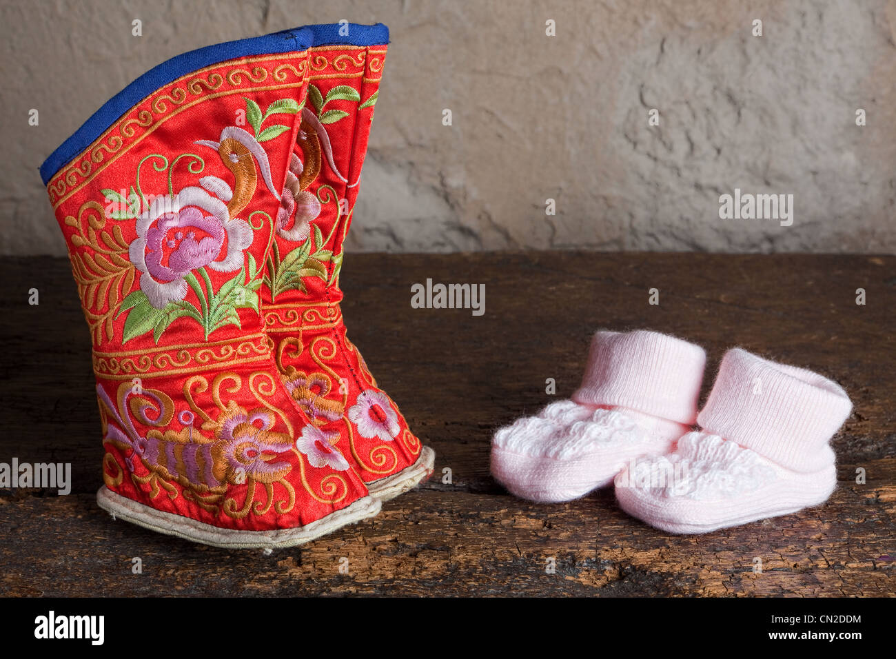 Adulto legato piedi scarpe cinese accanto al moderno baby calze Foto Stock