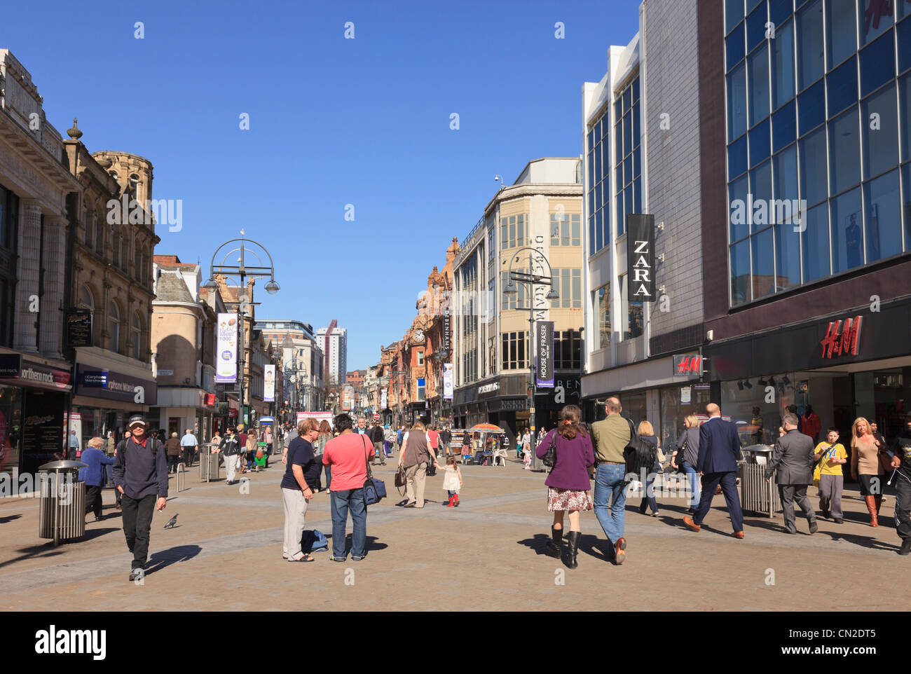 Occupato main high street scene con persone di shopping in centro città zona pedonale. Briggate, Leeds, West Yorkshire, Inghilterra, Regno Unito, Gran Bretagna Foto Stock