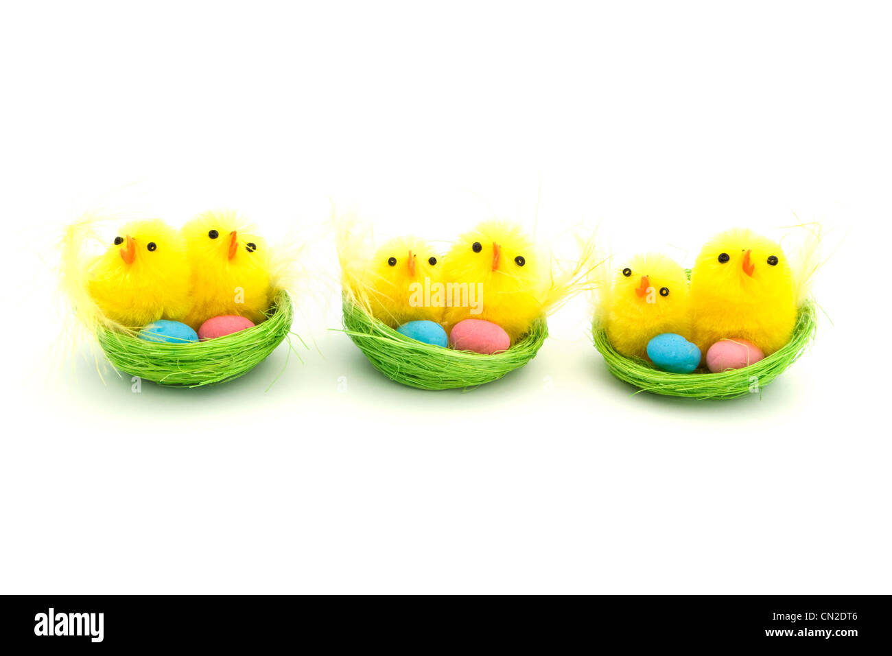 Tre pulcini di pasqua in un nido verde Foto Stock