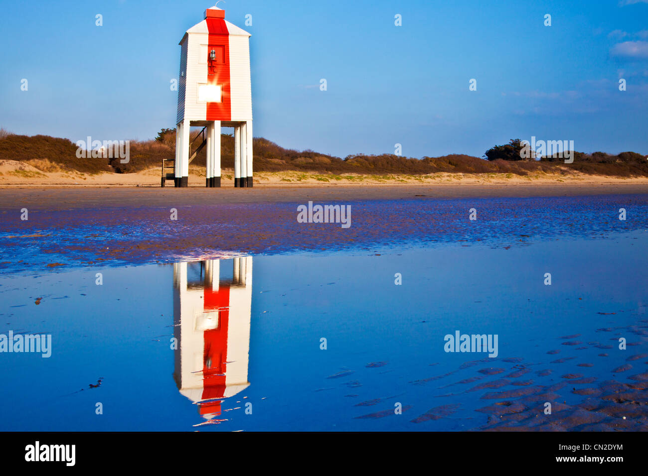 Il faro di insoliti su palafitte a Burnham-on-Sea, Somerset, Inghilterra, Regno Unito riflessa in un pool di marea Foto Stock