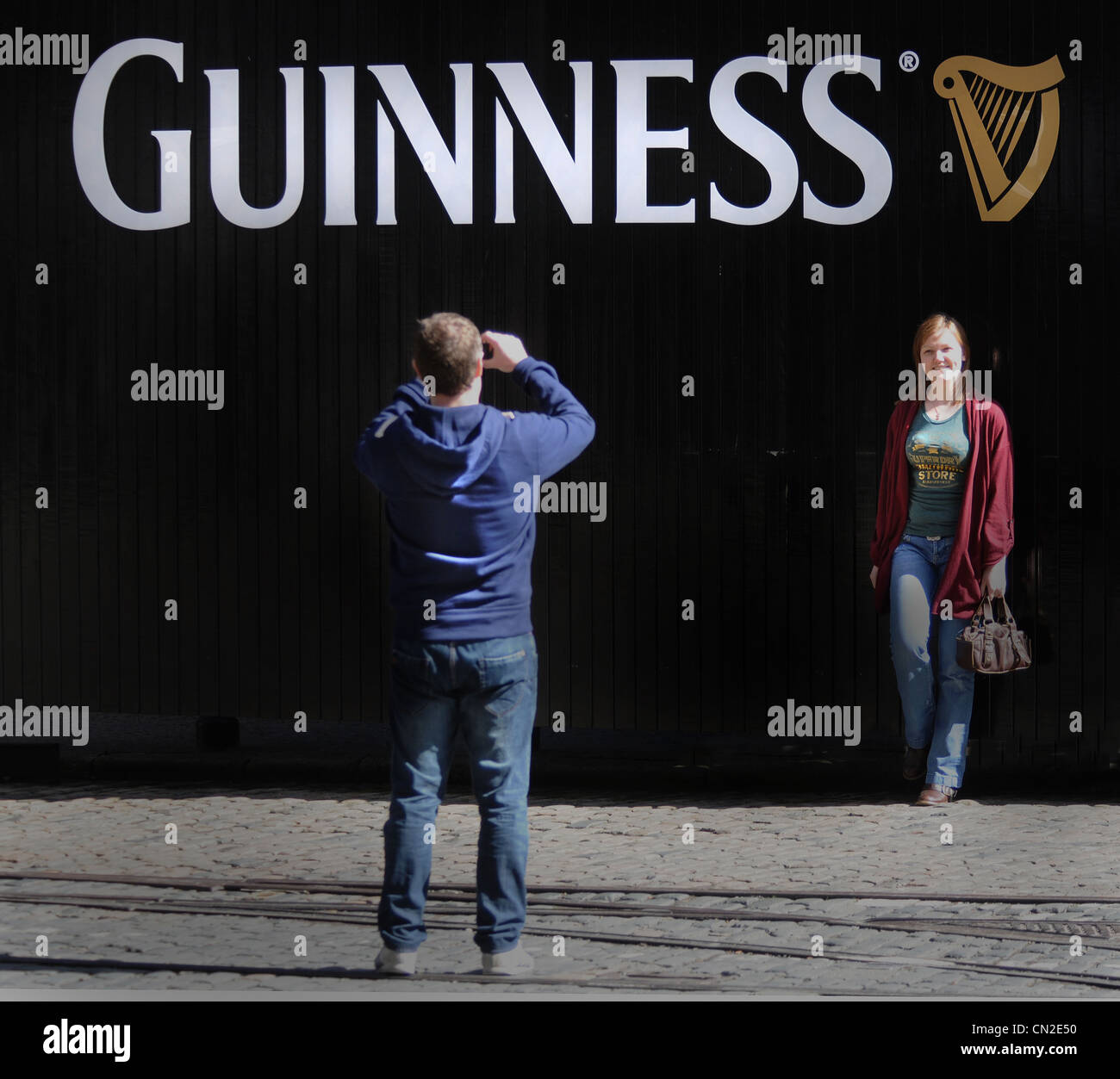 In posa per una foto al di fuori della famosa fabbrica di birra Guinnes a Dublino. Foto Stock