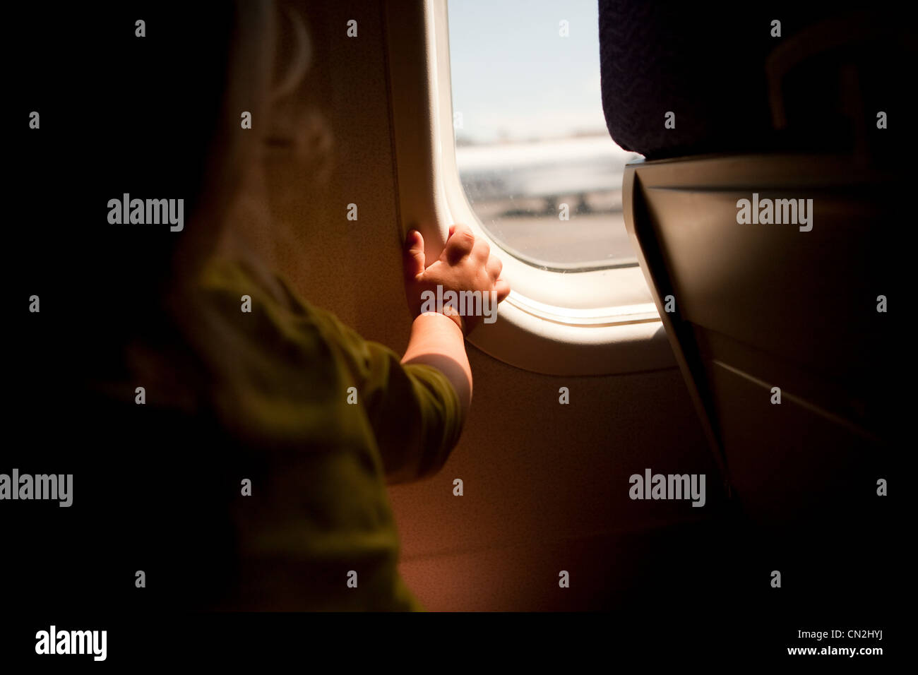 Il Toddler boy guardando attraverso la finestra di aeroplano Foto Stock