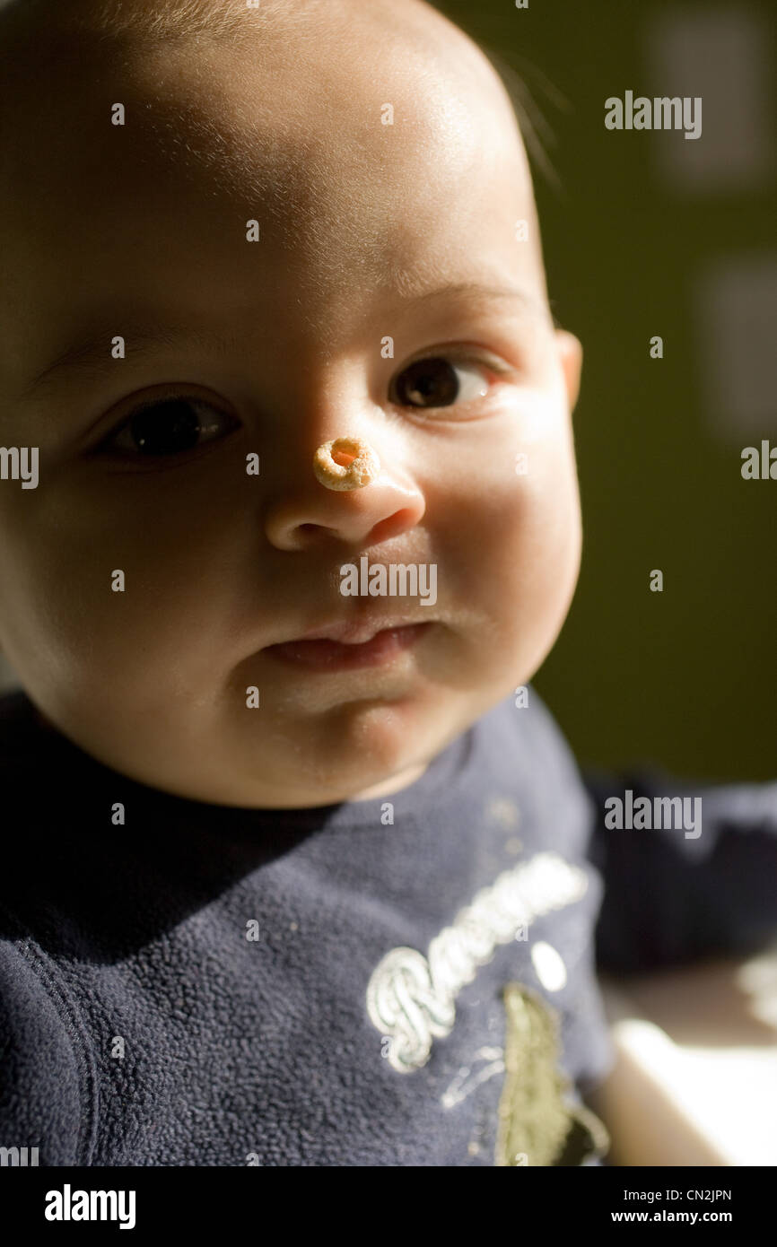 Baby boy con cereali per la prima colazione sul naso Foto Stock