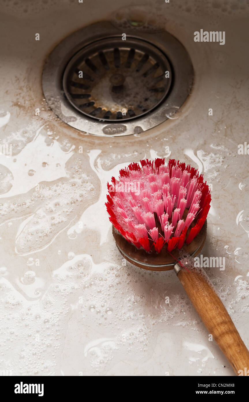 Spazzola per il lavaggio di stoviglie nel lavello da cucina Foto Stock
