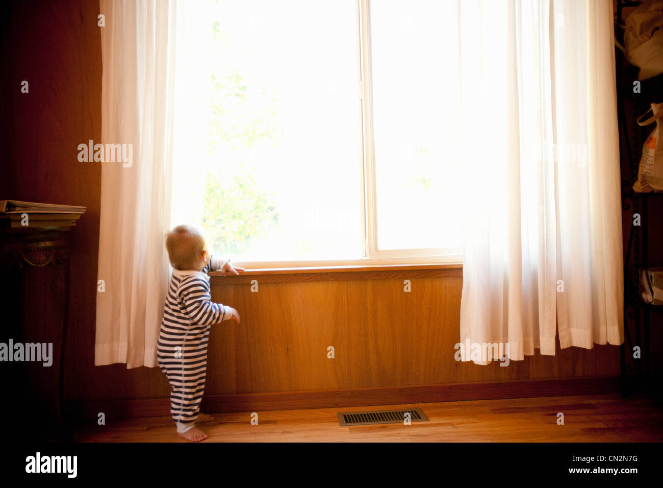 Il Toddler boy guardando fuori della finestra Foto Stock