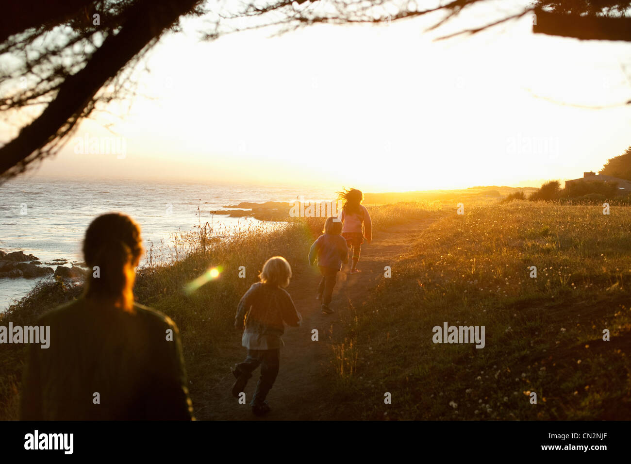 Famiglia a piedi dal litorale al tramonto Foto Stock