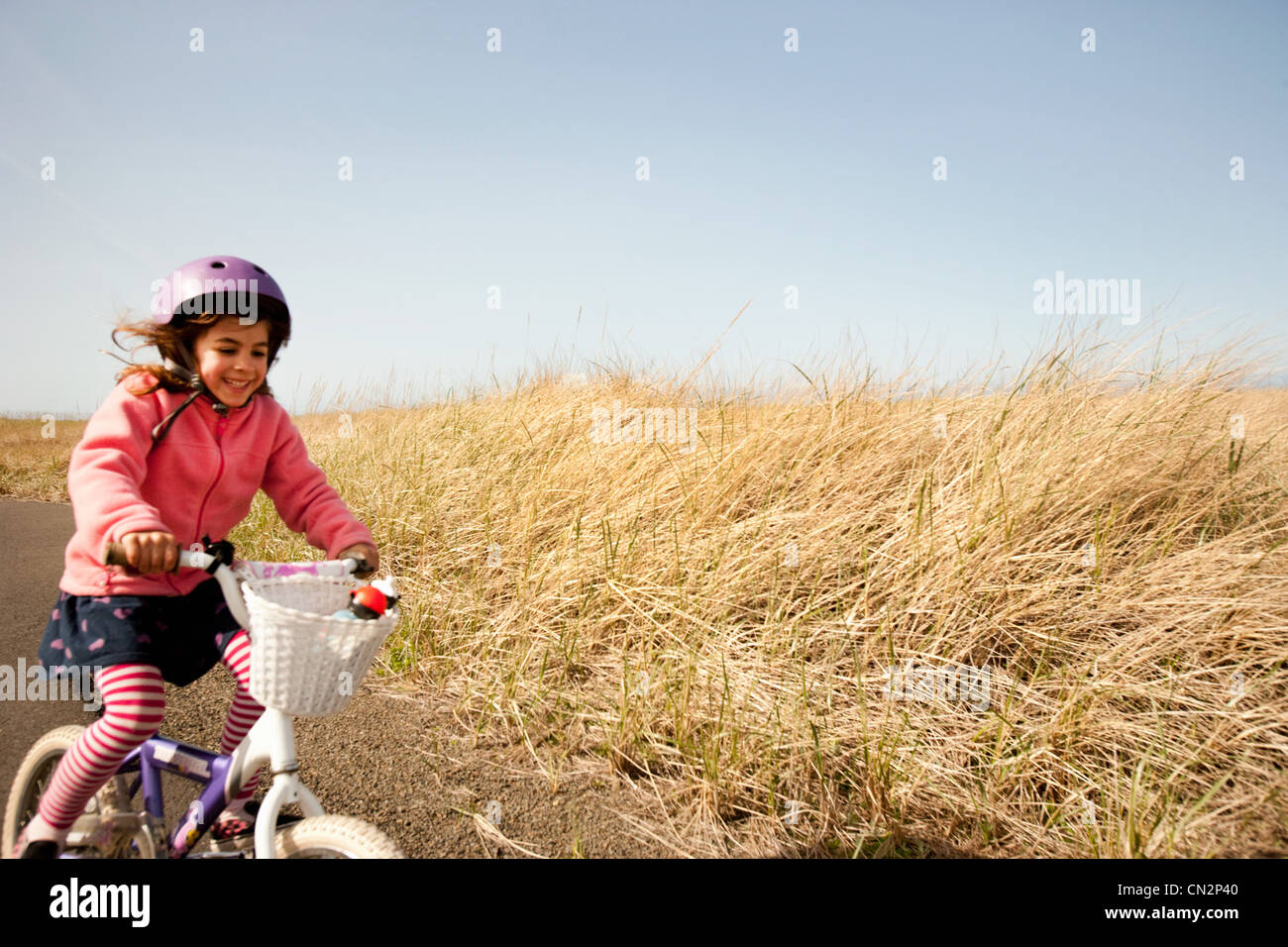 Giovane ragazza in bicicletta lungo la corsia Foto Stock