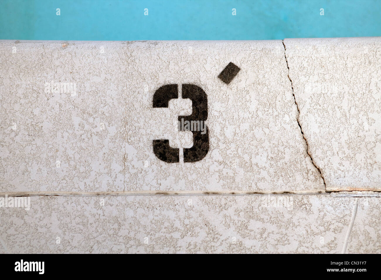 A bordo piscina con numero 3 in corrispondenza del bordo Foto Stock