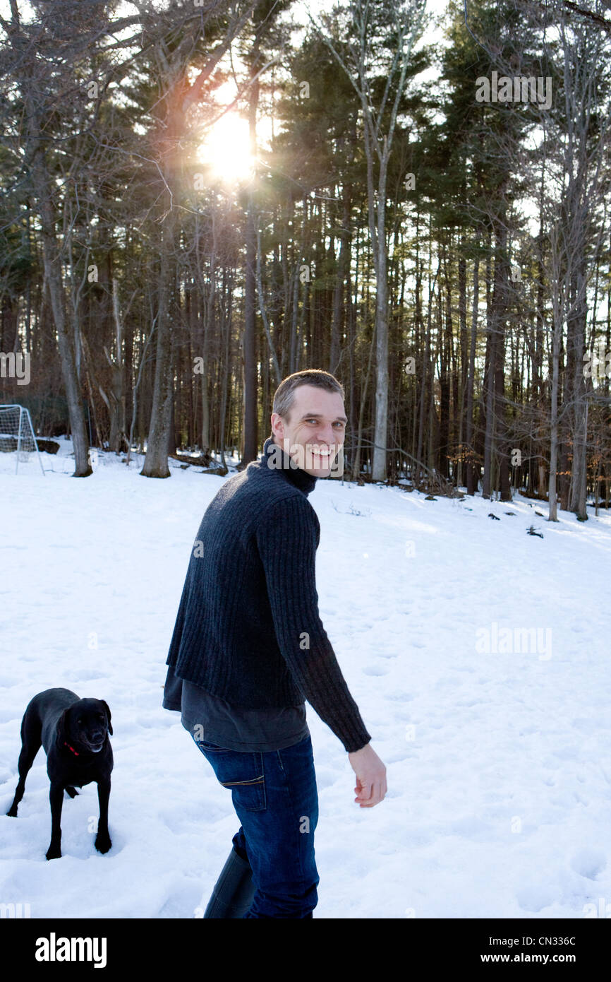 L'uomo con il cane nella foresta nella neve Foto Stock