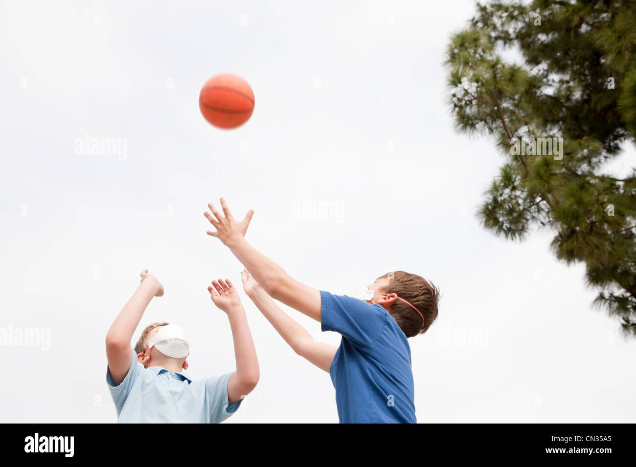 Due ragazzi che indossano maschere antipolvere giocare a basket Foto Stock