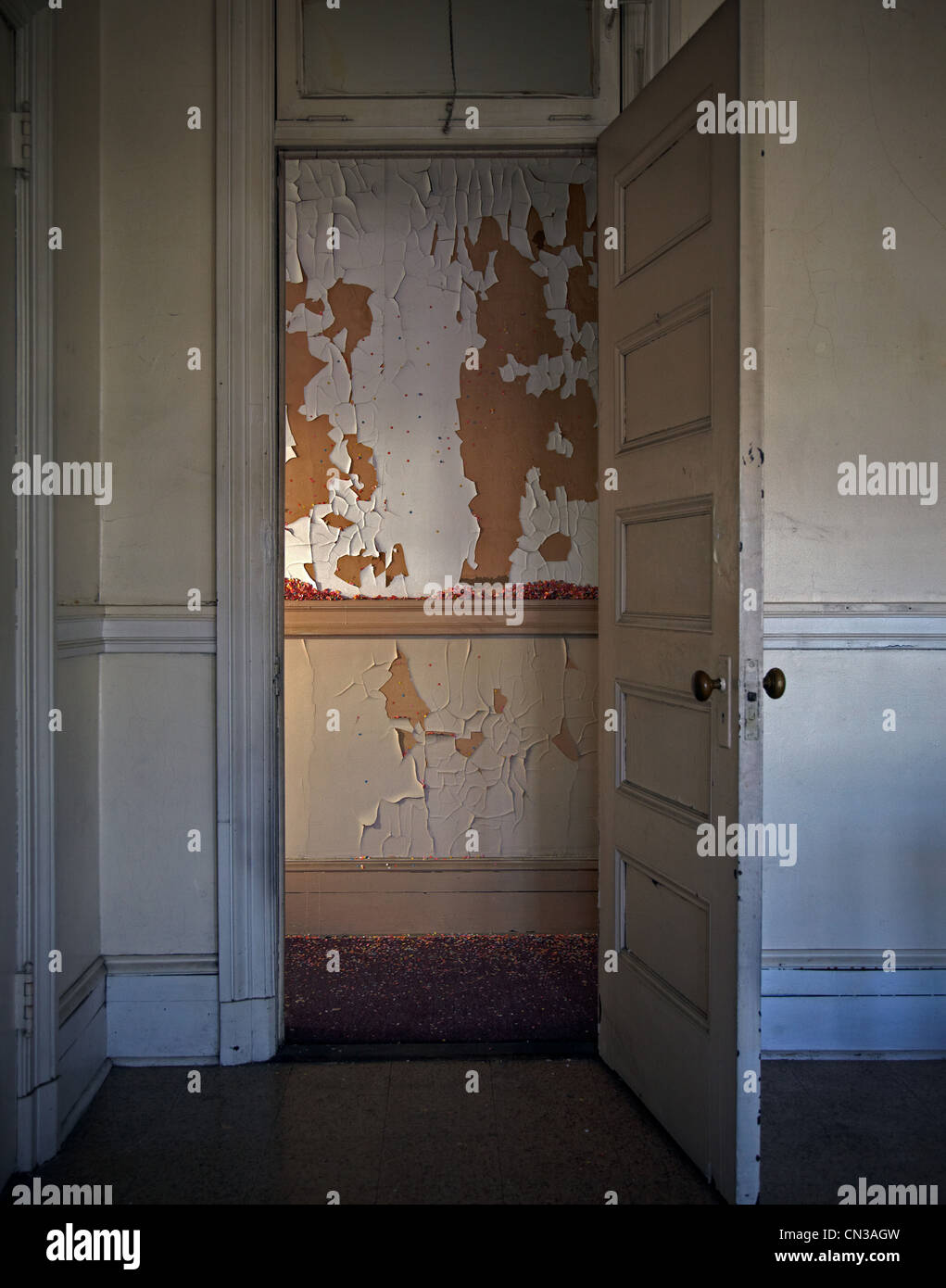 Vernice scrostata dalla parete visto attraverso la porta Foto Stock