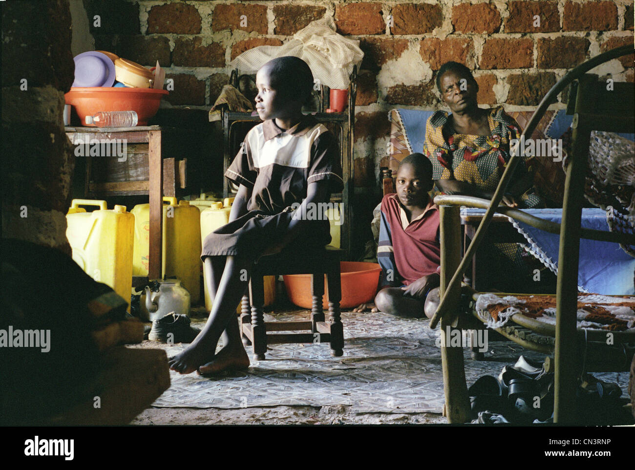 Una giovane ragazza africana guarda fuori la finestra con la famiglia Foto Stock