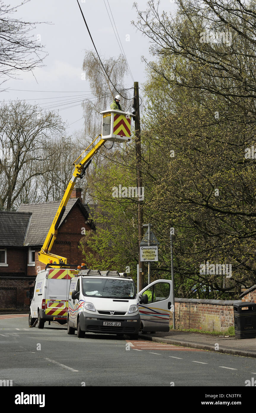 Openreach veicoli in strada con ingegnere di lavoro sul palo del telefono utilizzando la piattaforma idraulica Foto Stock