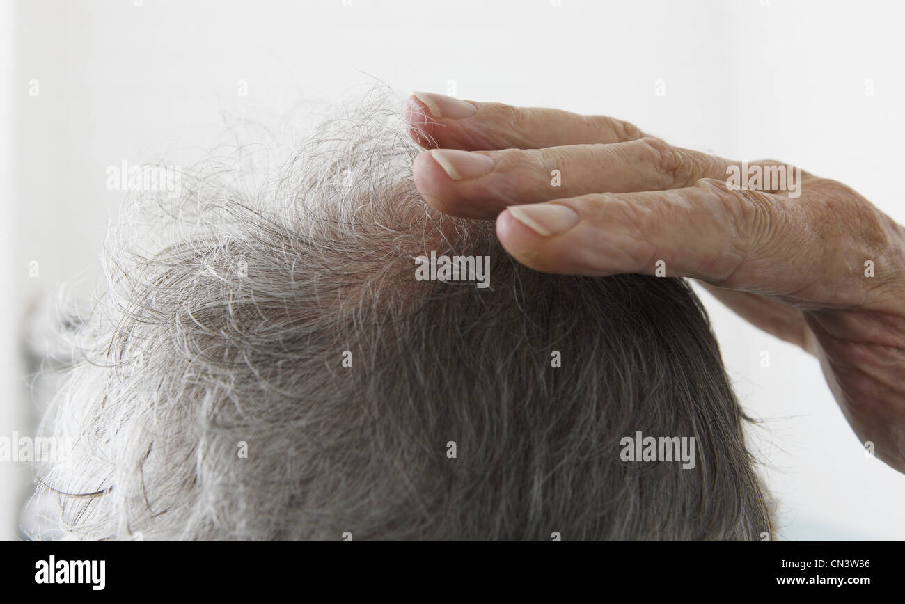 Senior uomo toccando bald spot Foto Stock