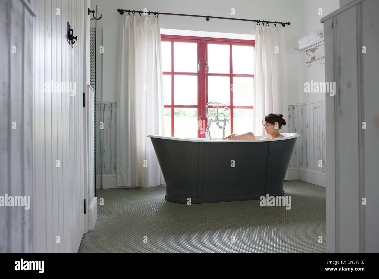 Donna godendo il bagno in bagno moderno Foto Stock