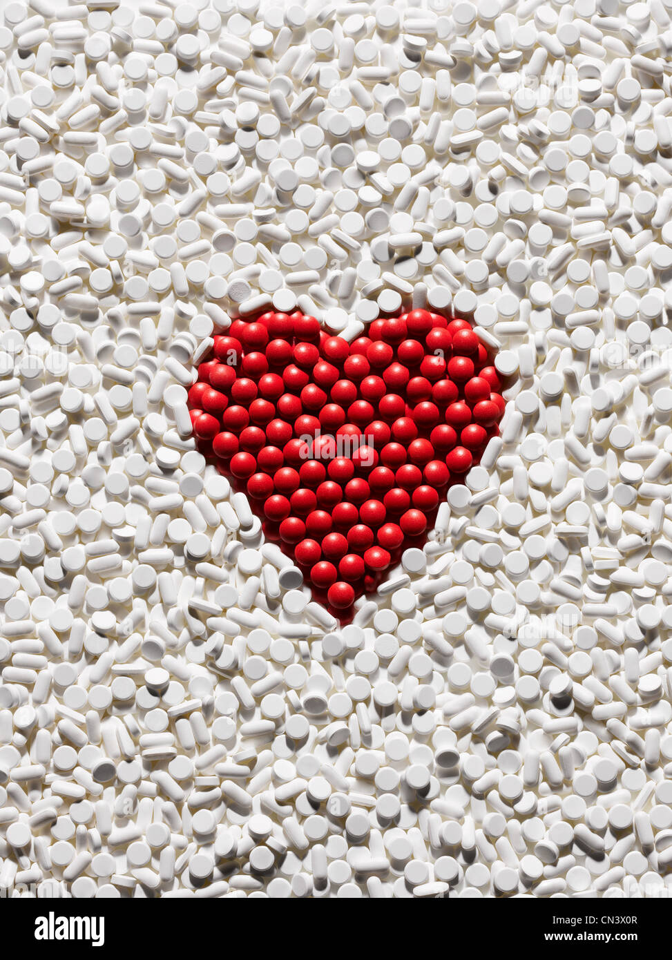 Pillole di rosso disposti in forma di cuore Foto Stock