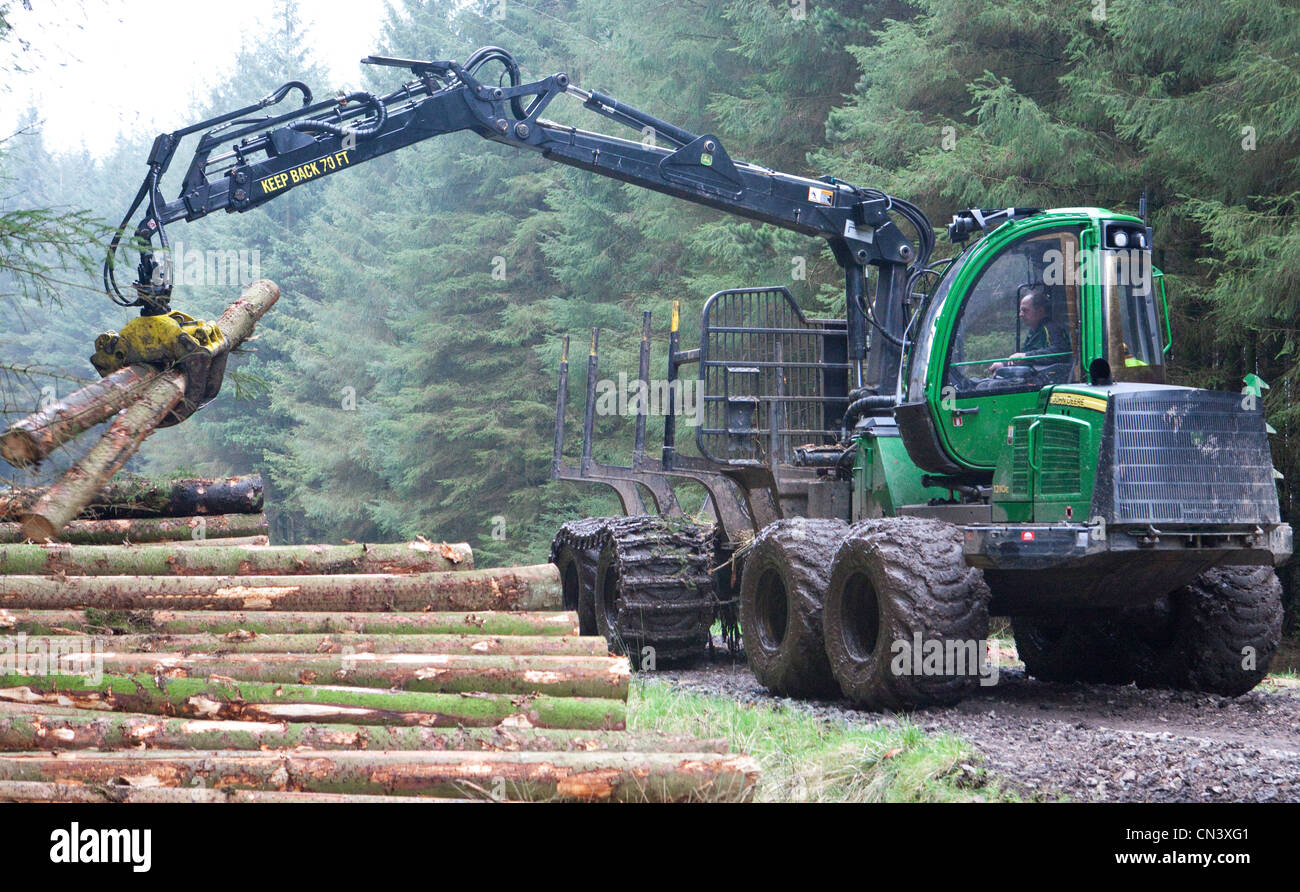Silvicoltura commerciale di spedizioniere, veicolo fuoristrada, operando il prelievo di tagliare il legname degli alberi della foresta commissione forestale, REGNO UNITO Foto Stock