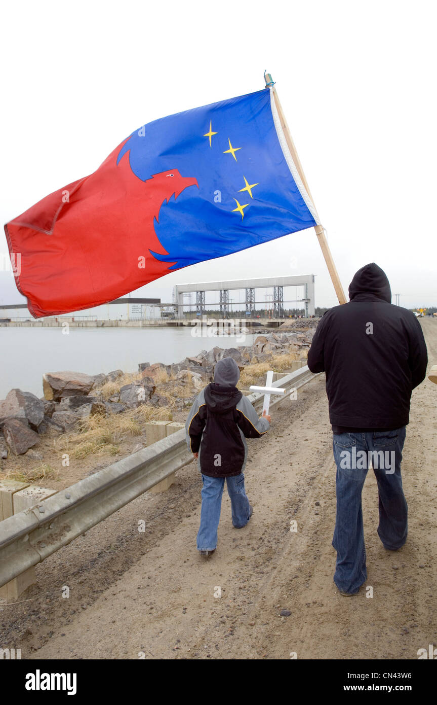 Nativo di maschi adulti con nativo bambino maschio holding bandiera aborigena a Idro Damn, attraversare il lago, Manitoba Foto Stock